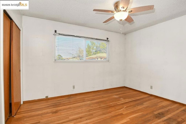 unfurnished room featuring light hardwood / wood-style floors, a textured ceiling, and ceiling fan