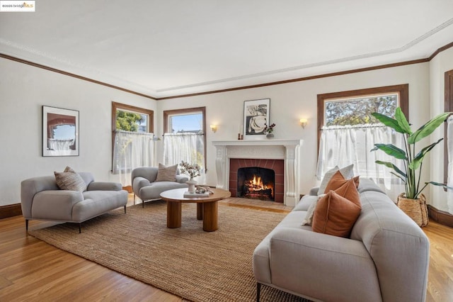 living room featuring a brick fireplace, light hardwood / wood-style flooring, and ornamental molding