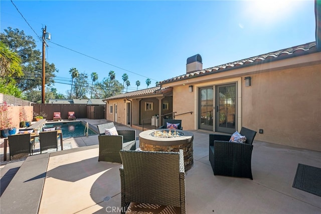 view of patio / terrace with a fenced in pool and an outdoor fire pit