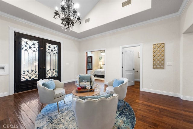 sitting room with a chandelier, french doors, high vaulted ceiling, ornamental molding, and dark wood-type flooring