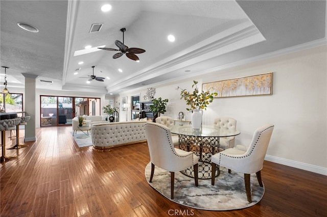 dining room featuring ornamental molding, hardwood / wood-style floors, and a tray ceiling