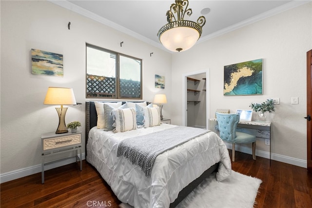 bedroom featuring a spacious closet, dark hardwood / wood-style floors, a closet, and crown molding