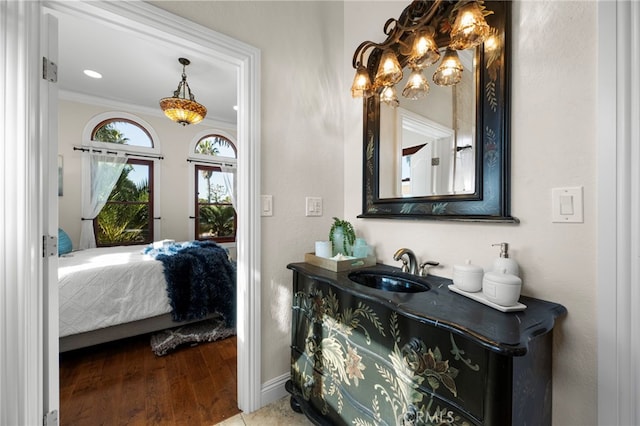 bedroom featuring crown molding, sink, and hardwood / wood-style flooring