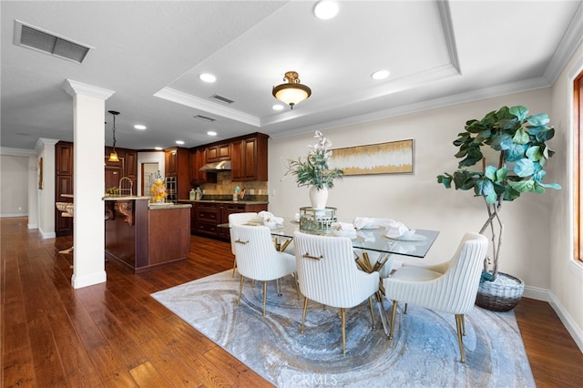 dining room featuring crown molding, dark hardwood / wood-style floors, and a tray ceiling