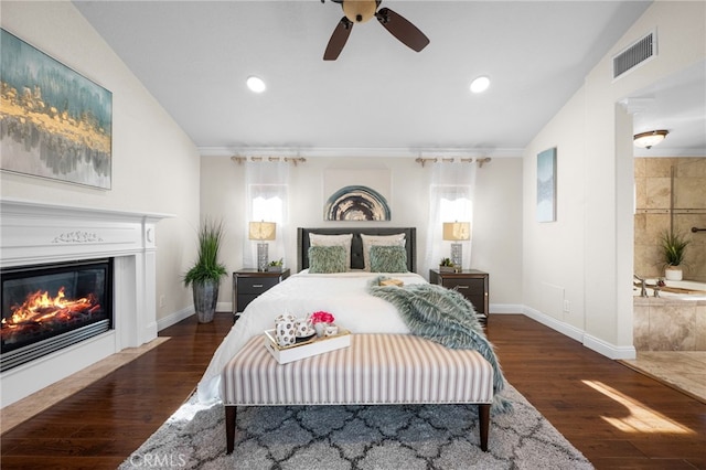 bedroom with crown molding, dark wood-type flooring, vaulted ceiling, and ceiling fan