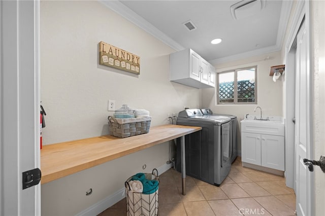 washroom featuring sink, separate washer and dryer, crown molding, and cabinets