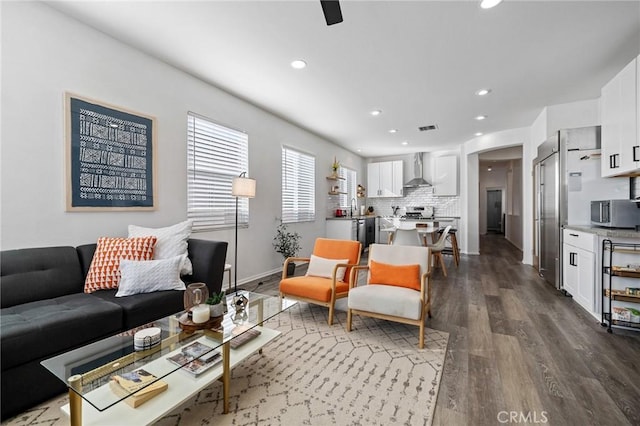 living area featuring baseboards, visible vents, dark wood finished floors, and recessed lighting