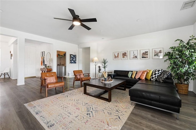 living room with ceiling fan, visible vents, and wood finished floors