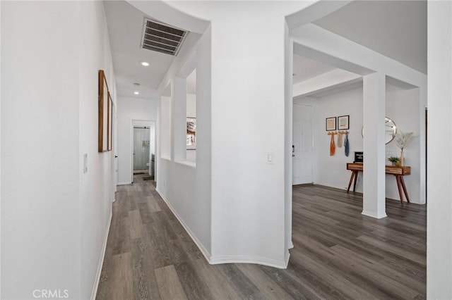 corridor with dark wood-style floors, recessed lighting, visible vents, and baseboards