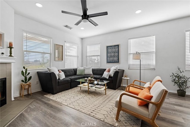 living room featuring a fireplace, recessed lighting, visible vents, a ceiling fan, and wood finished floors