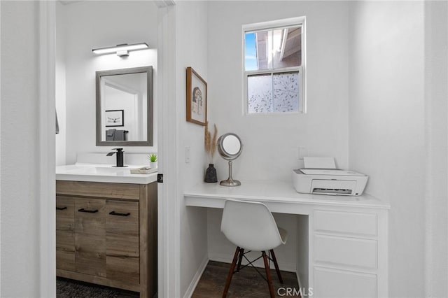 bathroom featuring vanity, baseboards, and wood finished floors