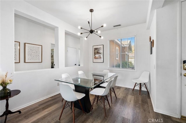 dining area with a chandelier, visible vents, baseboards, and wood finished floors