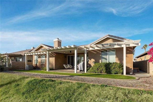 back of property with a patio, a yard, stucco siding, and a pergola