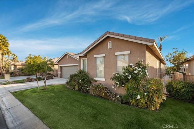 view of front of house featuring a garage, driveway, a front lawn, and stucco siding