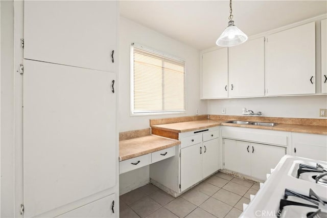 kitchen with sink, hanging light fixtures, white cabinets, and light tile patterned flooring