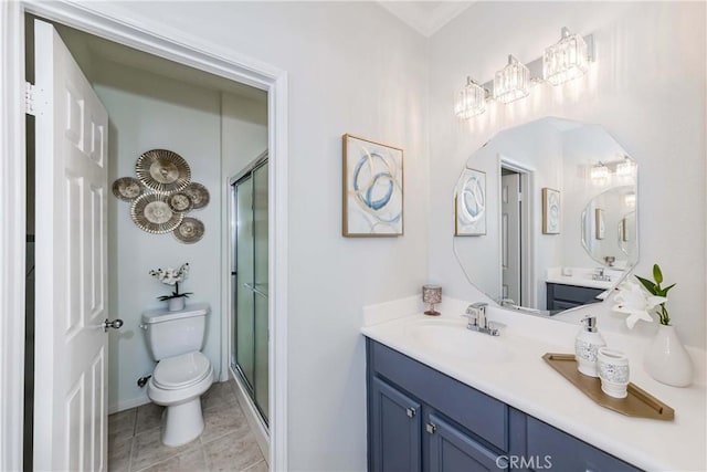 bathroom featuring a shower with shower door, toilet, vanity, and tile patterned flooring