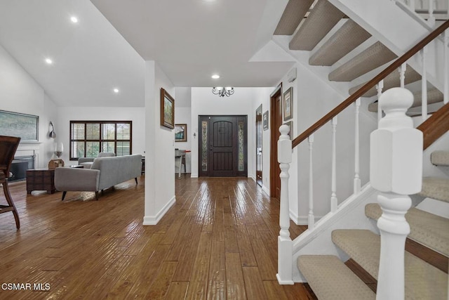 entryway featuring high vaulted ceiling, hardwood / wood-style floors, and a notable chandelier