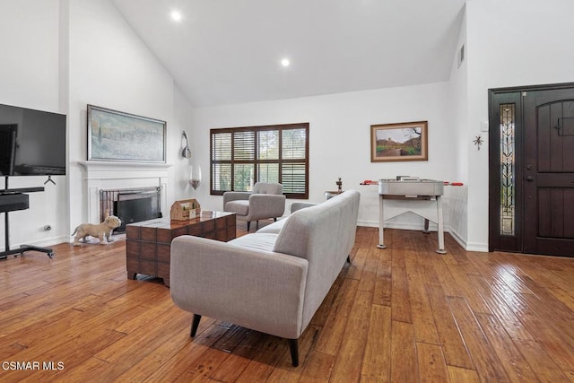 living room featuring light hardwood / wood-style floors and high vaulted ceiling