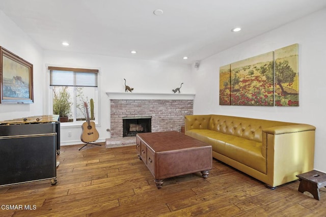 living room featuring hardwood / wood-style flooring and a brick fireplace