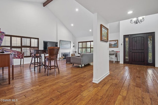 entrance foyer featuring high vaulted ceiling, a chandelier, hardwood / wood-style floors, and beamed ceiling