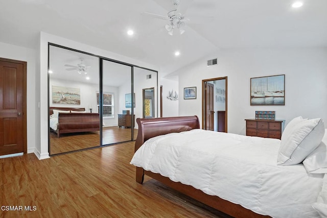 bedroom with ceiling fan, hardwood / wood-style flooring, a closet, and vaulted ceiling