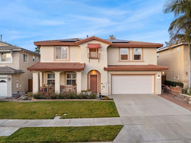 mediterranean / spanish home with a garage, a front lawn, solar panels, and a porch