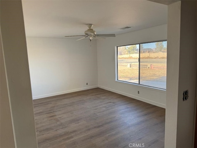 unfurnished room featuring ceiling fan and dark hardwood / wood-style flooring