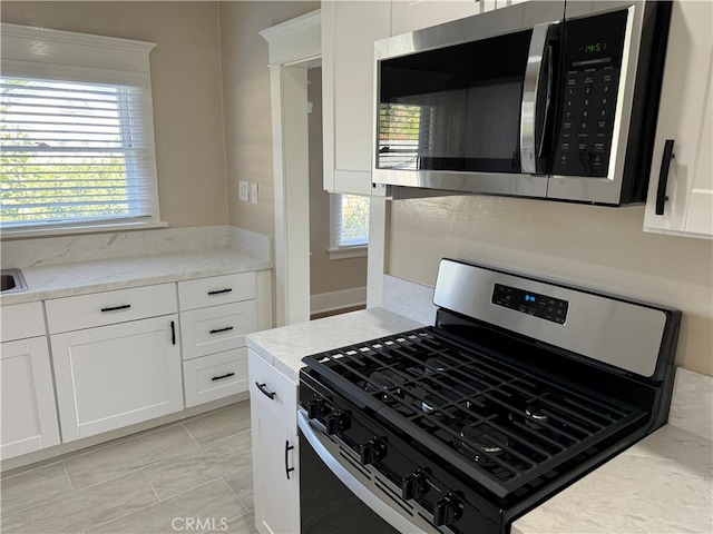 kitchen with white cabinets and appliances with stainless steel finishes