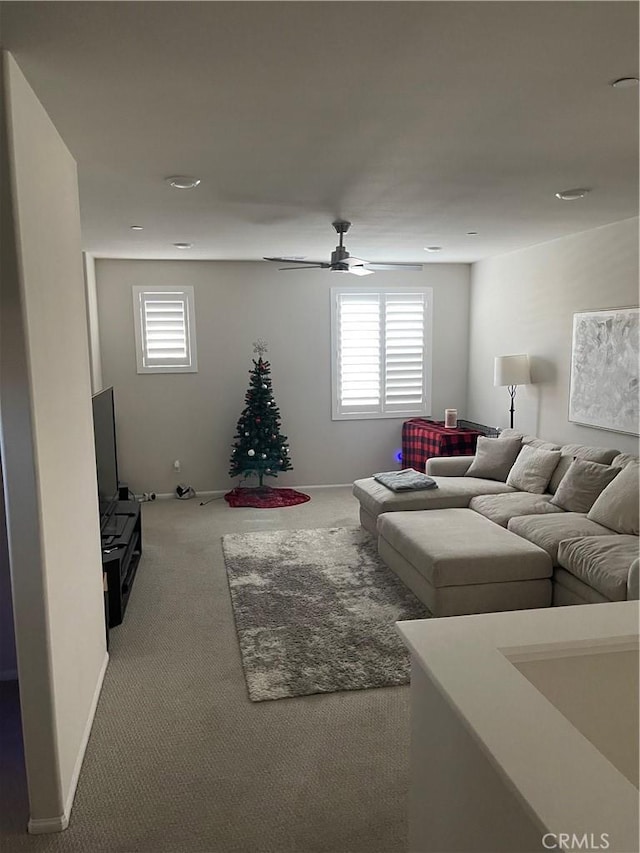 carpeted living room with ceiling fan