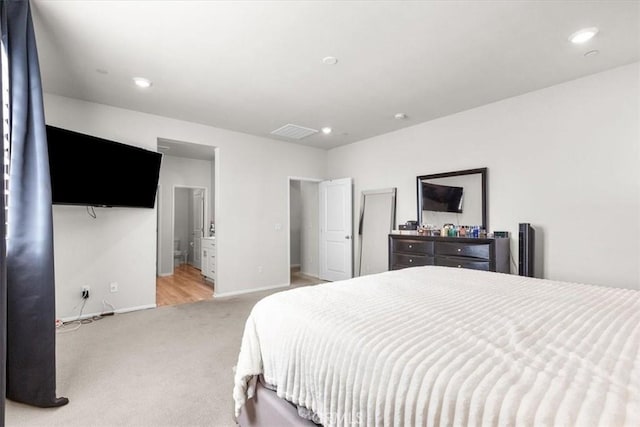 bedroom featuring light carpet and connected bathroom