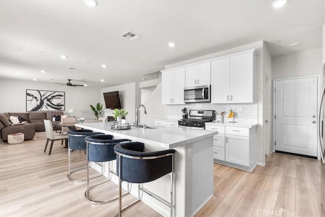 kitchen with white cabinetry, sink, an island with sink, and appliances with stainless steel finishes