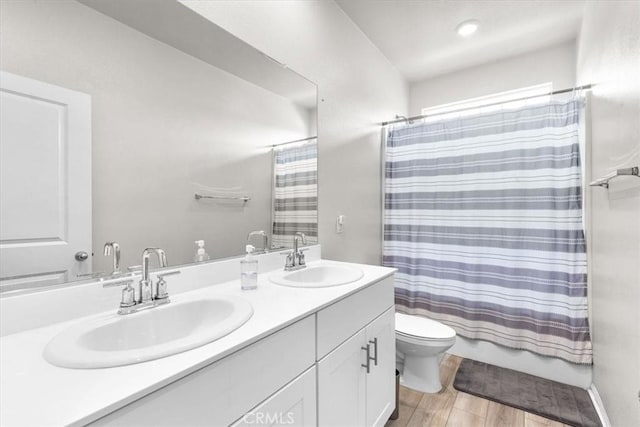 full bathroom with hardwood / wood-style flooring, vanity, toilet, and shower / bath combo with shower curtain