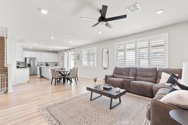 living room featuring ceiling fan and light wood-type flooring