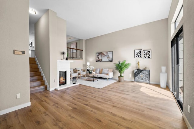 interior space with stairs, a fireplace, wood finished floors, and baseboards