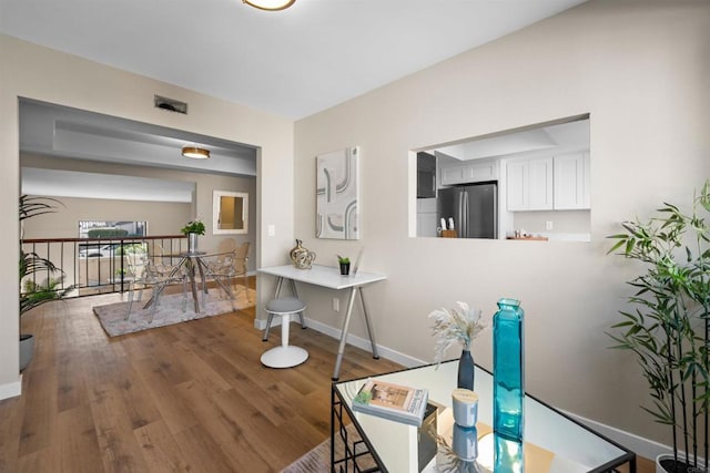 hallway featuring wood finished floors and baseboards