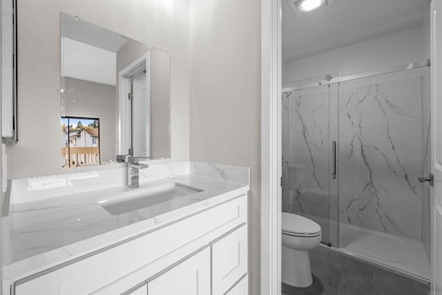 full bathroom featuring a marble finish shower, vanity, and toilet