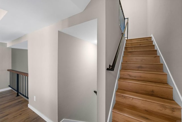 stairway featuring baseboards and wood finished floors