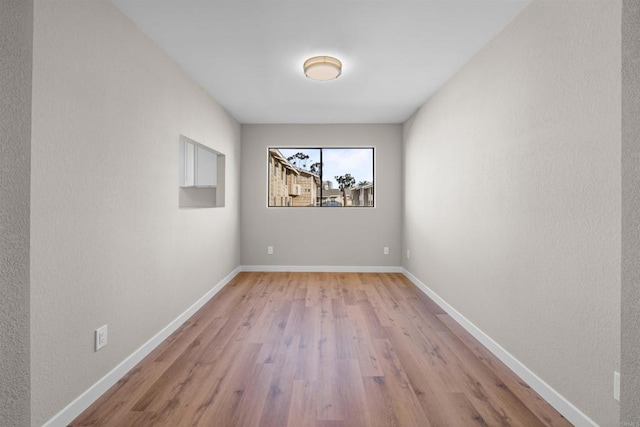 spare room with light wood finished floors and baseboards