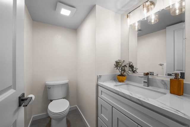 bathroom with tile patterned flooring, baseboards, vanity, and toilet