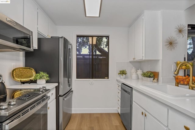 kitchen featuring white cabinets, appliances with stainless steel finishes, and sink