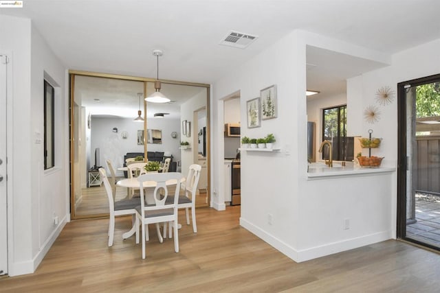 dining area with sink and light hardwood / wood-style flooring