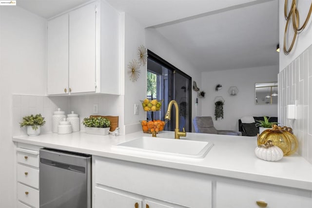 kitchen featuring white cabinets, tasteful backsplash, stainless steel dishwasher, and sink