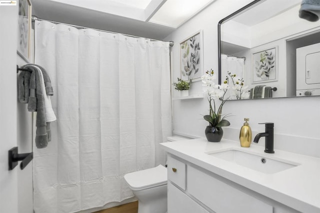 bathroom featuring stacked washer / dryer, toilet, and vanity