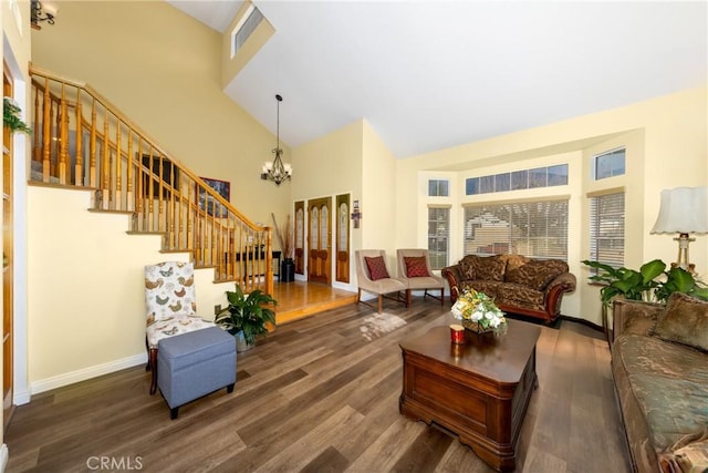 living room with a high ceiling, an inviting chandelier, and dark hardwood / wood-style flooring