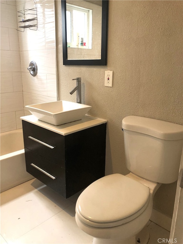 full bathroom featuring vanity, toilet, tiled shower / bath, and tile patterned flooring