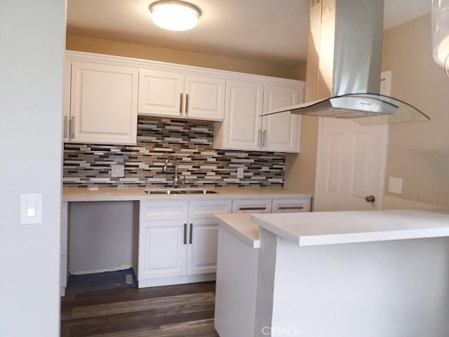 kitchen featuring sink, white cabinetry, and island exhaust hood