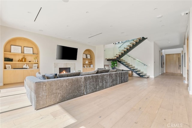 living room with light wood-type flooring and built in shelves