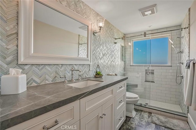 bathroom featuring vanity, an enclosed shower, and toilet