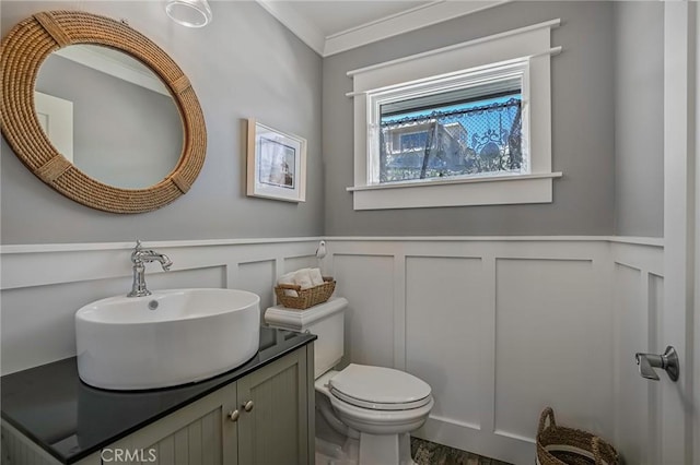 bathroom with ornamental molding, vanity, and toilet