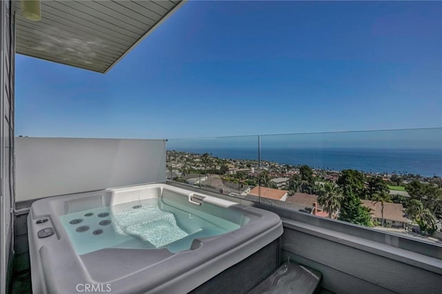 balcony featuring a water view and a hot tub